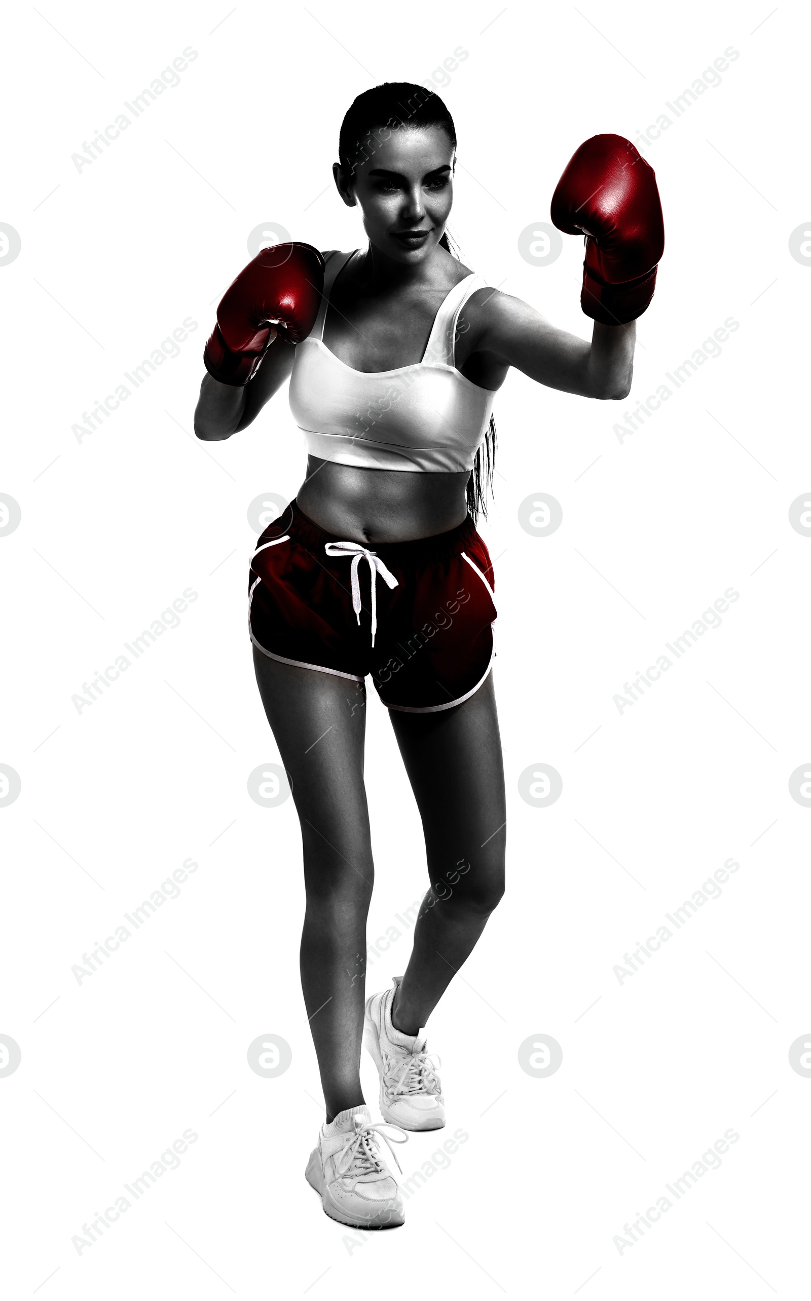 Image of Woman in red boxing gloves training on white background. Black-and-white effect with color accent