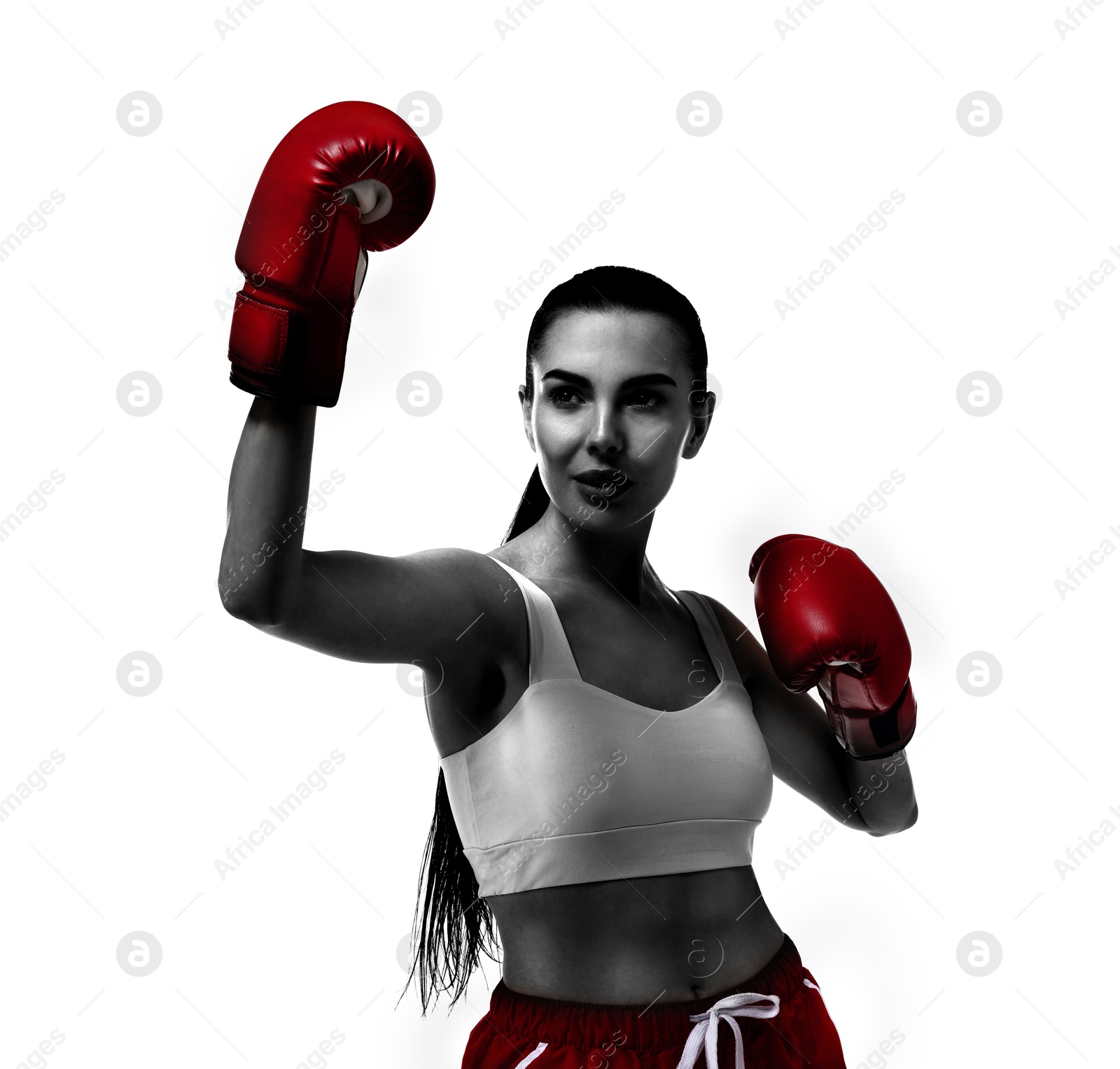 Image of Woman in red boxing gloves training on white background. Black-and-white effect with color accent