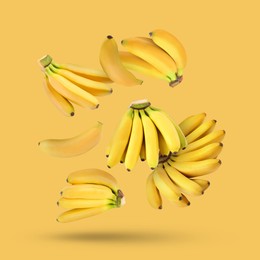 Image of Many fresh bananas falling on yellow background