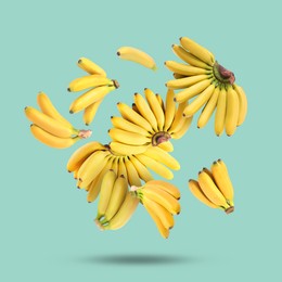 Image of Many yellow bananas falling on turquoise background