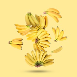 Image of Many fresh bananas falling on yellow background