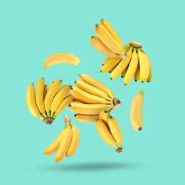 Image of Many yellow bananas falling on turquoise background