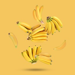 Image of Many fresh bananas falling on yellow background