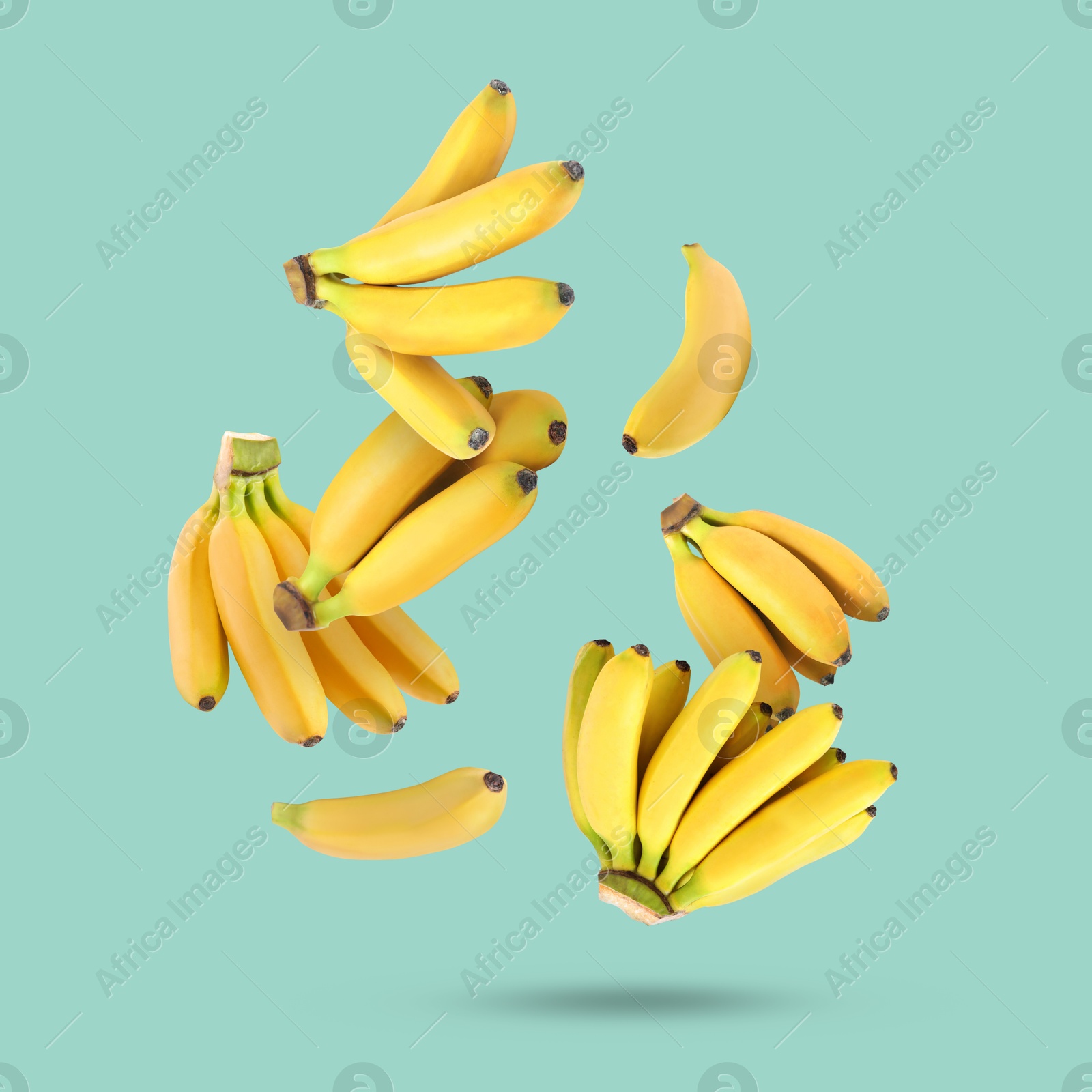 Image of Many yellow bananas falling on turquoise background