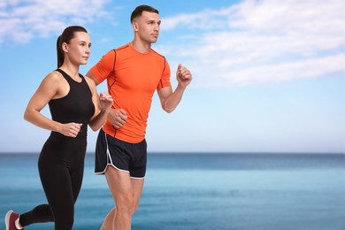 Couple in sportive clothes running on beach. Space for text