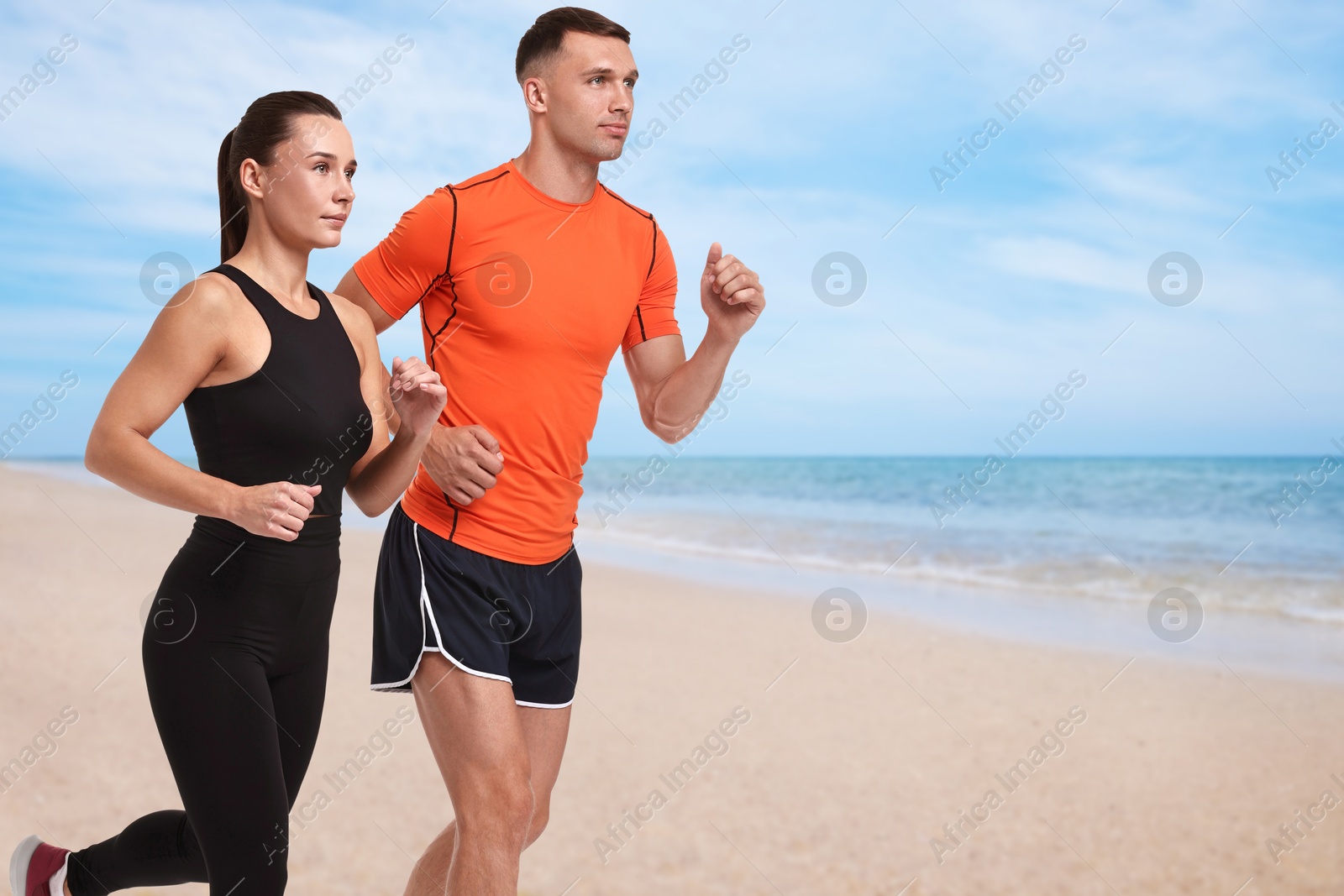 Image of Couple in sportive clothes running on beach. Space for text