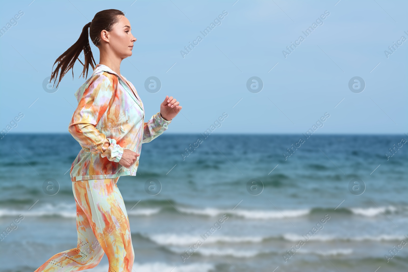 Image of Beautiful woman running on beach. Space for text