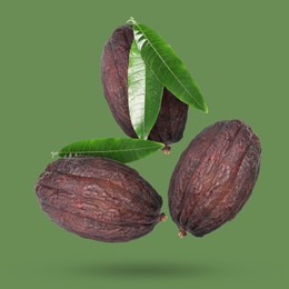 Image of Cocoa pods and leaves in air on green background