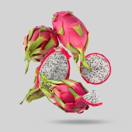 Image of Yummy pitaya fruits falling on light grey background