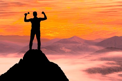 Winner with trophy cup in mountains at sunrise