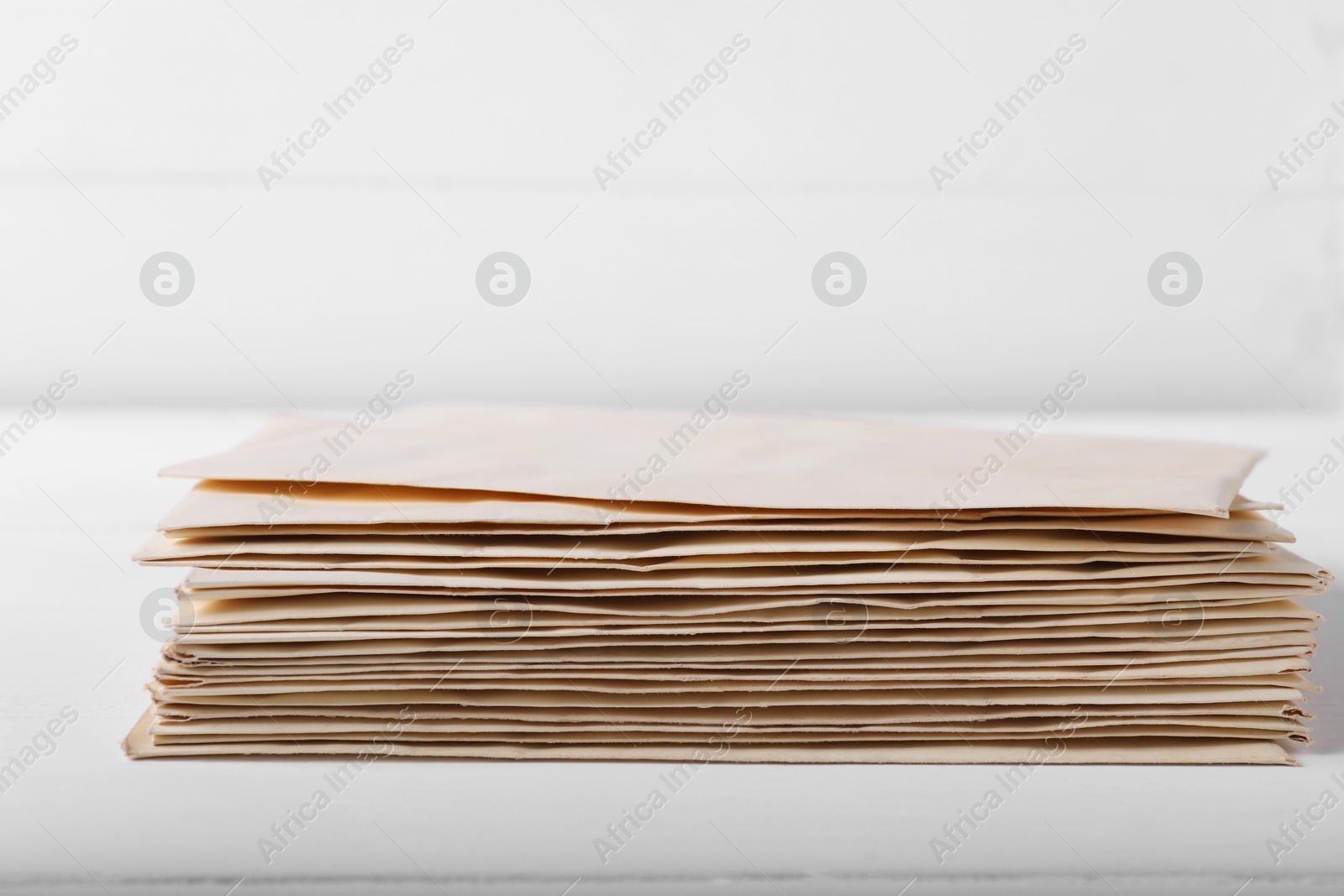 Photo of Stack of old letters on white wooden table, closeup