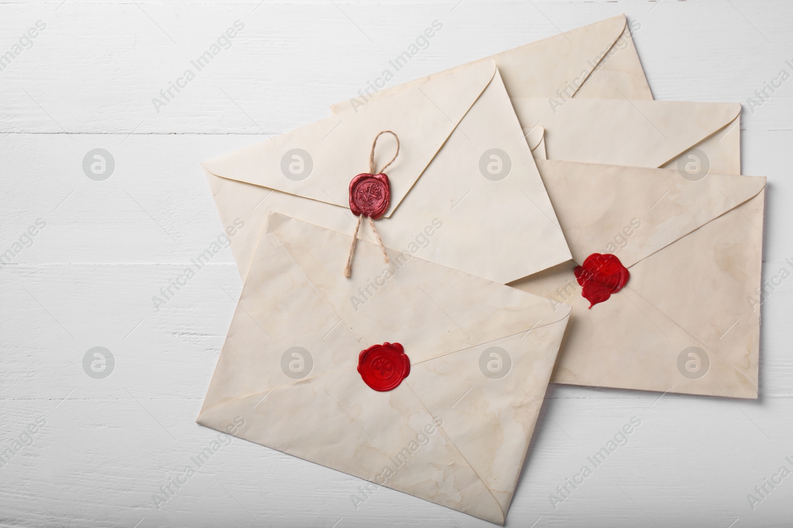 Photo of Old letter envelopes on white wooden table, top view