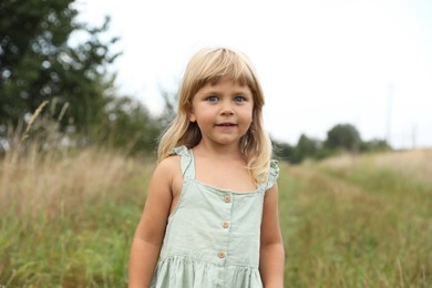 Photo of Portrait of cute little girl at meadow. Child enjoying beautiful nature