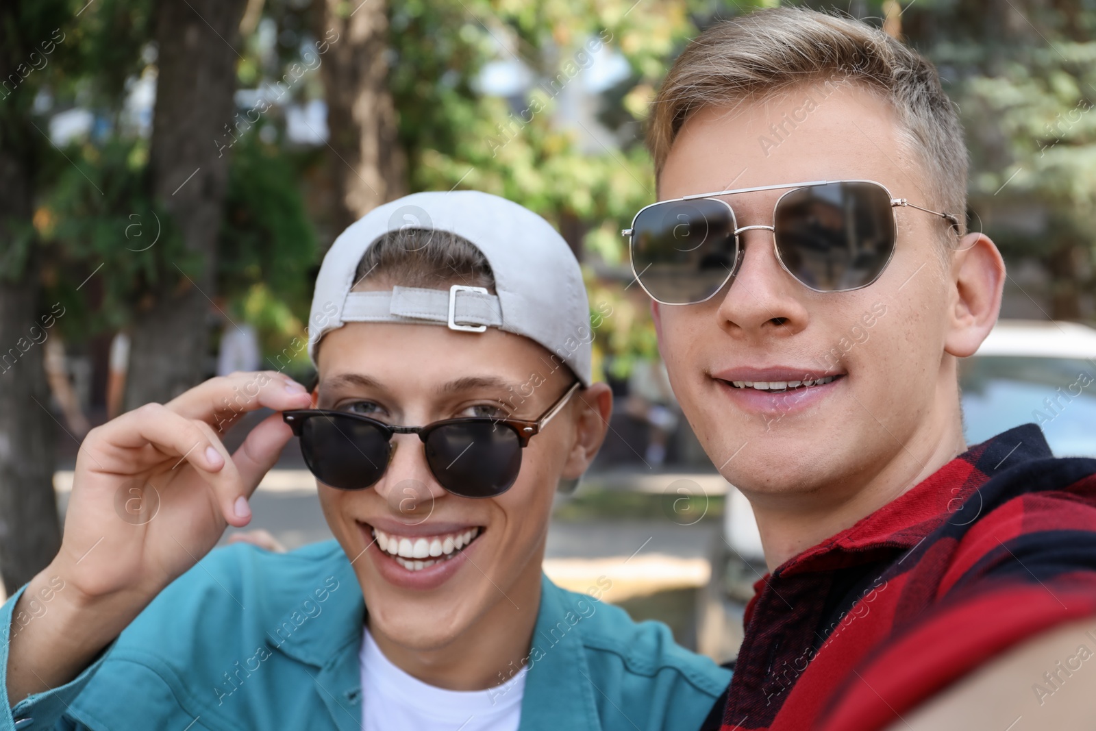 Photo of Family portrait of handsome brothers in sunglasses outdoors