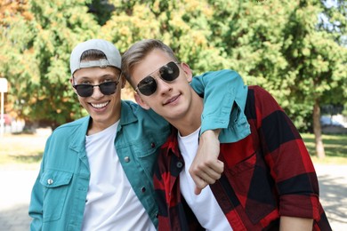 Family portrait of happy brothers in sunglasses outdoors