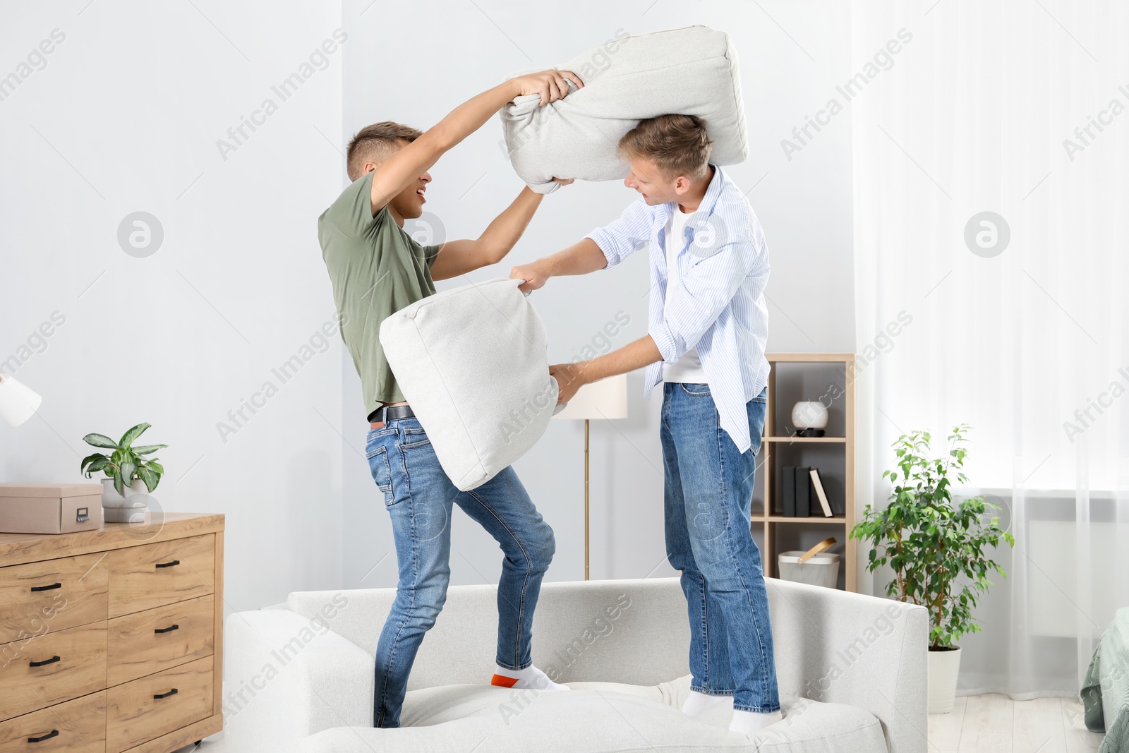 Photo of Young brothers having pillow fight at home