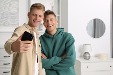 Photo of Happy brothers taking selfie at home. Space for text