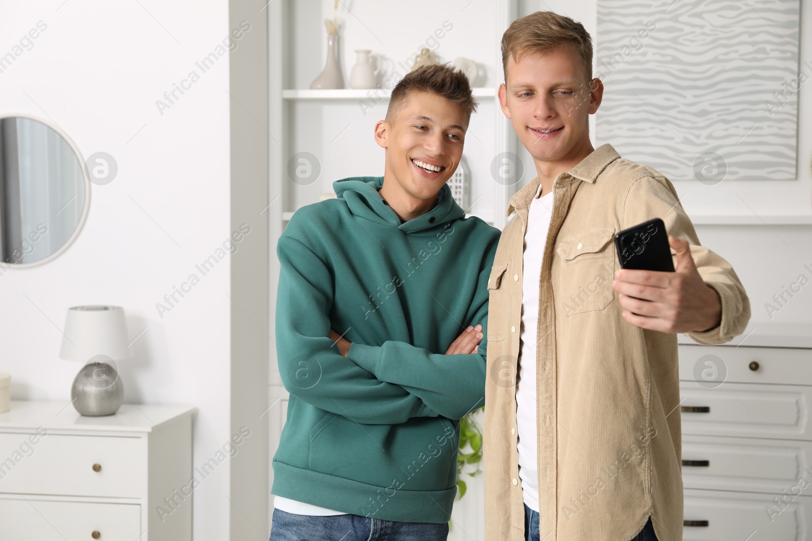 Photo of Happy brothers taking selfie at home. Space for text