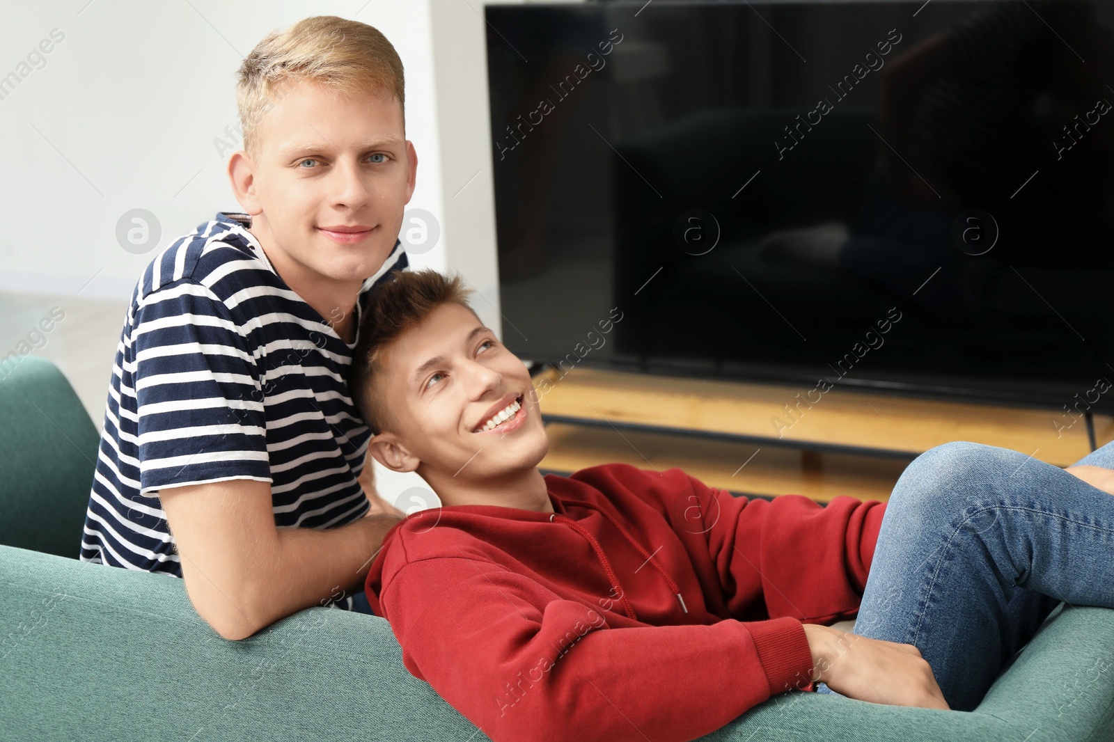 Photo of Family portrait of happy brothers on sofa at home