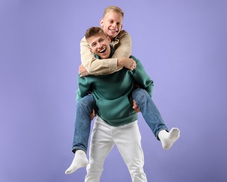 Happy brothers having fun on violet background