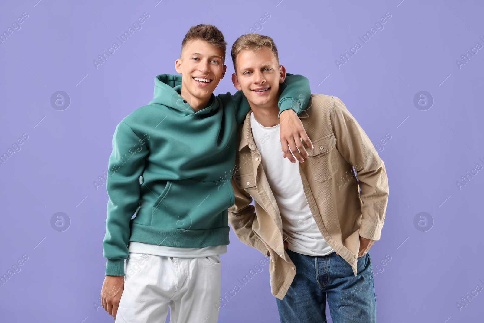 Photo of Portrait of happy brothers on violet background