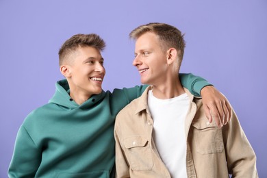 Photo of Portrait of happy brothers on violet background