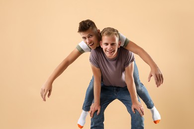 Portrait of happy brothers on beige background