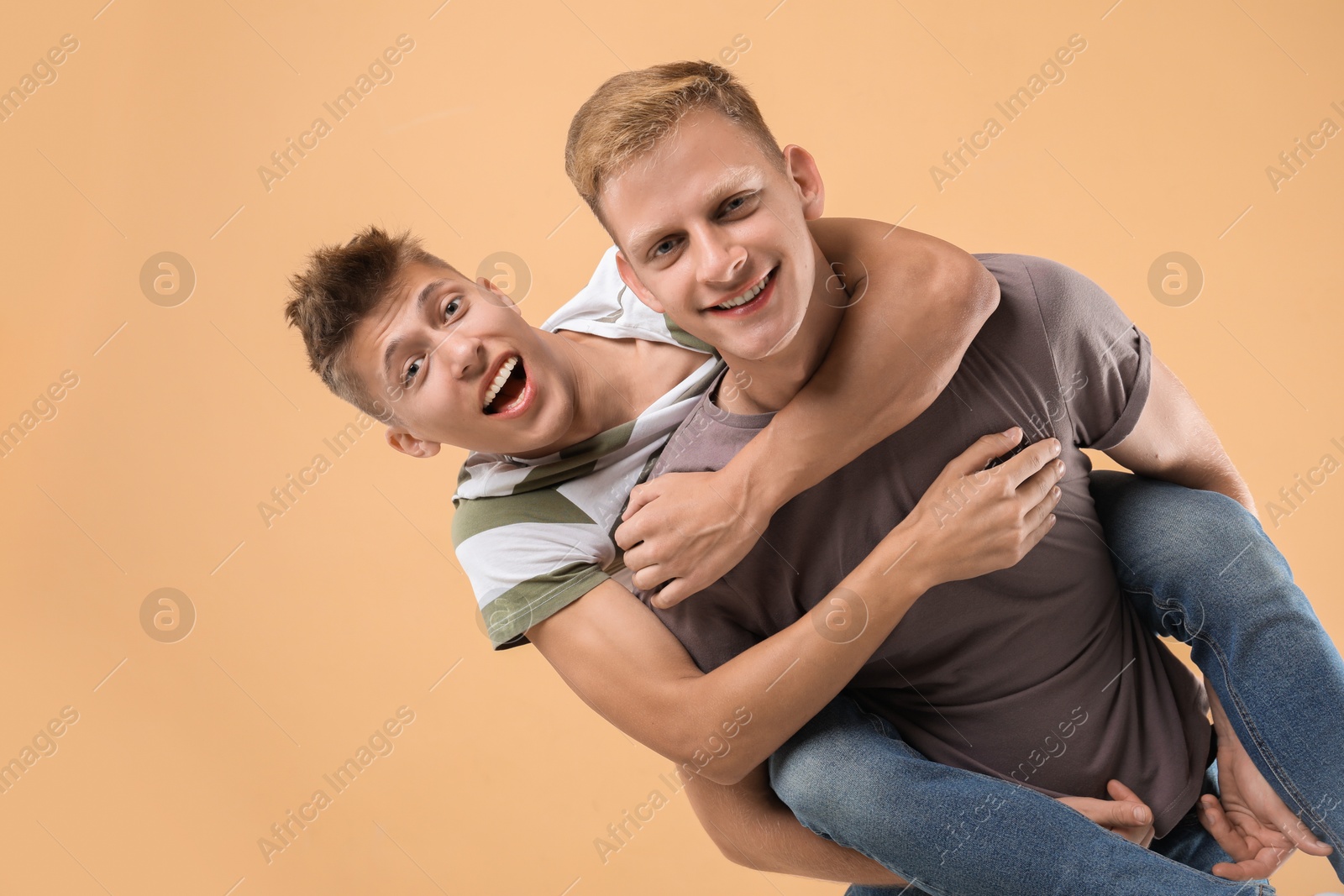 Photo of Portrait of happy brothers on beige background