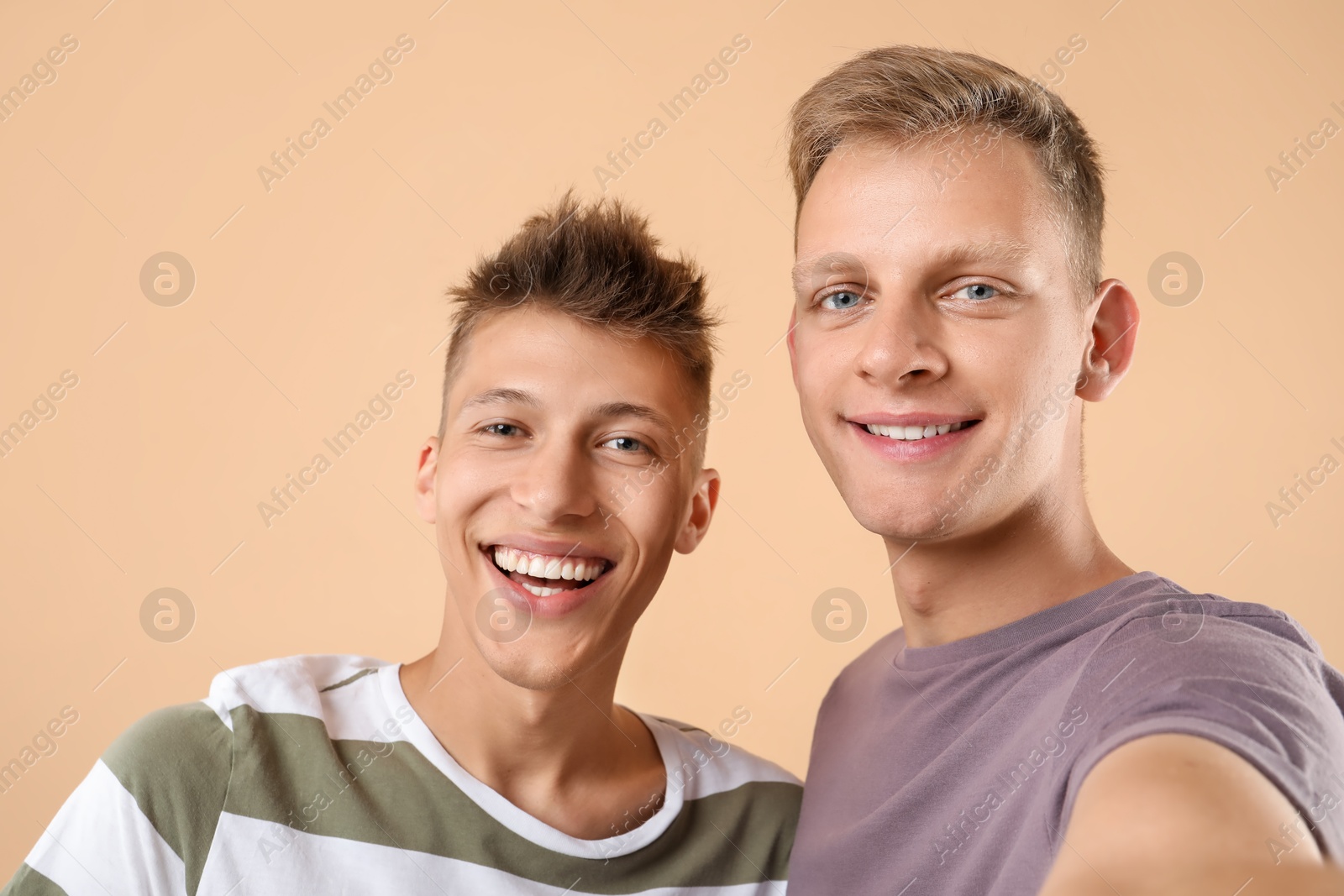 Photo of Portrait of happy brothers on beige background