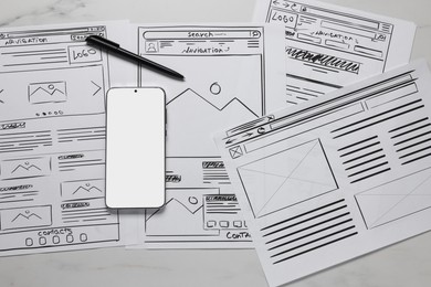 Photo of Developing UI design. Sketches of website wireframes, smartphone and pen on white marble table, top view