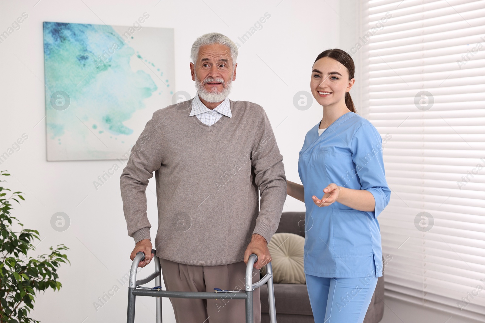 Photo of Nurse helping senior man with walking frame in clinic