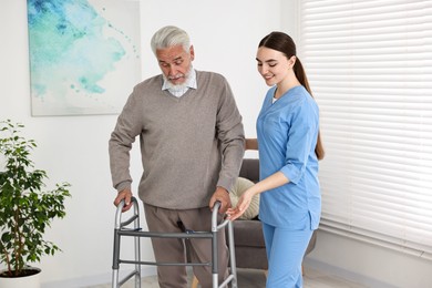 Photo of Nurse helping senior man with walking frame in clinic