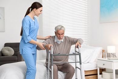 Photo of Nurse helping senior man with walking frame in clinic