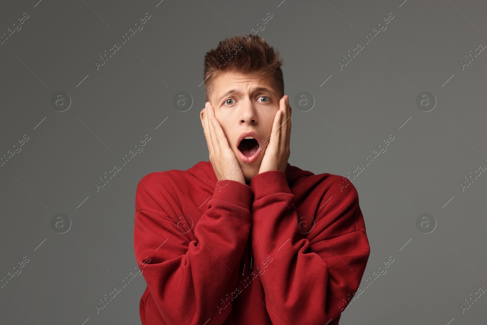 Photo of Portrait of scared young man on gray background