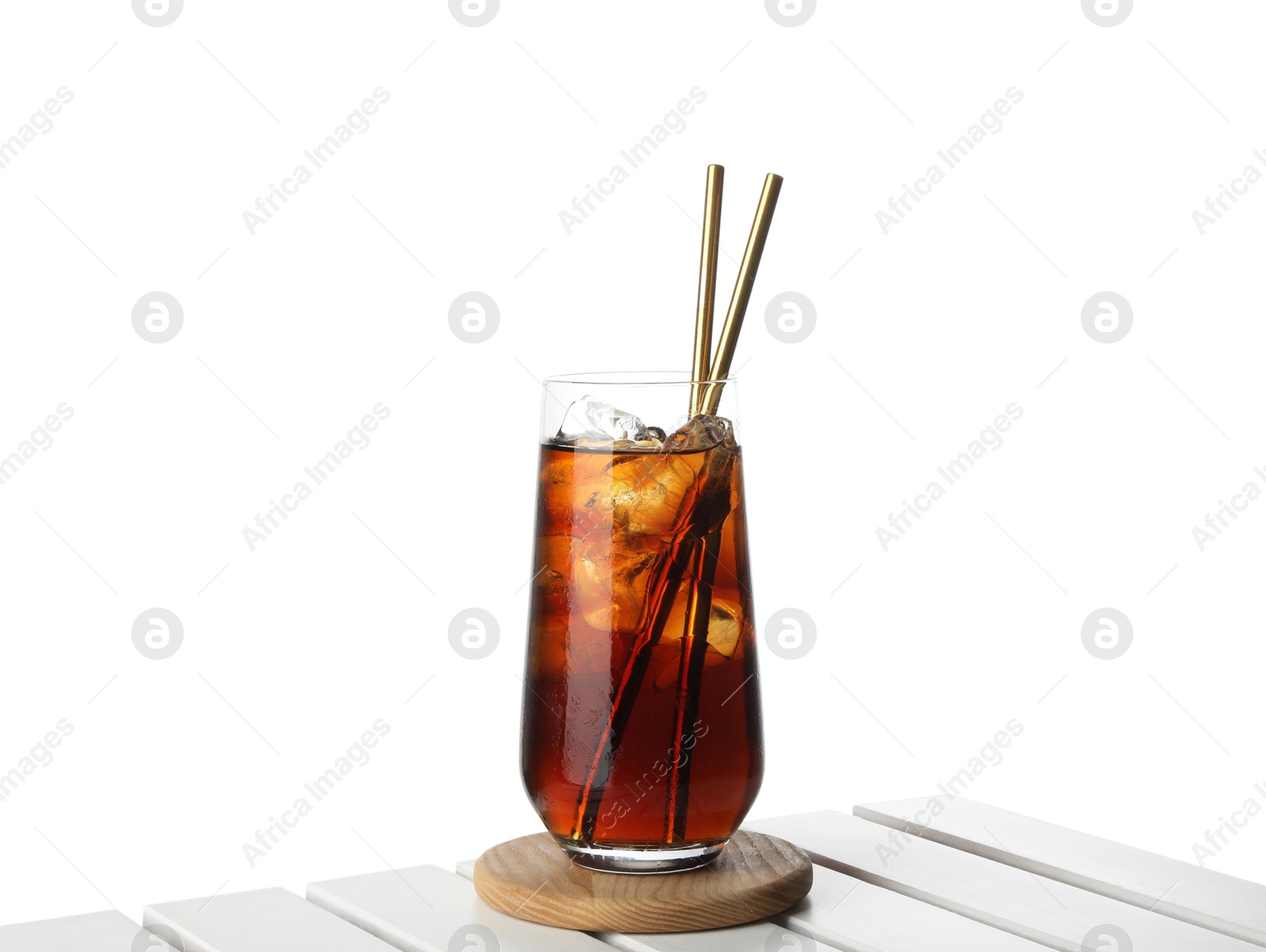 Photo of Glass of tasty refreshing drink and straws on wooden table against white background