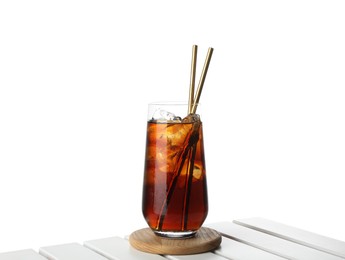 Photo of Glass of tasty refreshing drink and straws on wooden table against white background