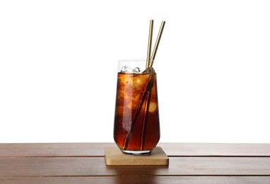 Glass of tasty refreshing drink and straws on wooden table against white background