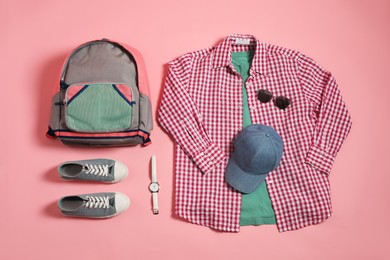 Photo of Stylish outfit with backpack on pink background, flat lay