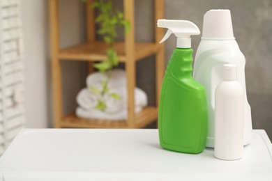 Photo of Different laundry detergents in bottles on white table indoors. Space for text