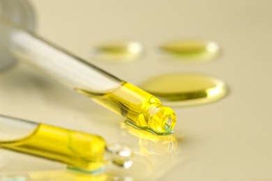 Photo of Cosmetic oil and pipettes on dark beige background, closeup