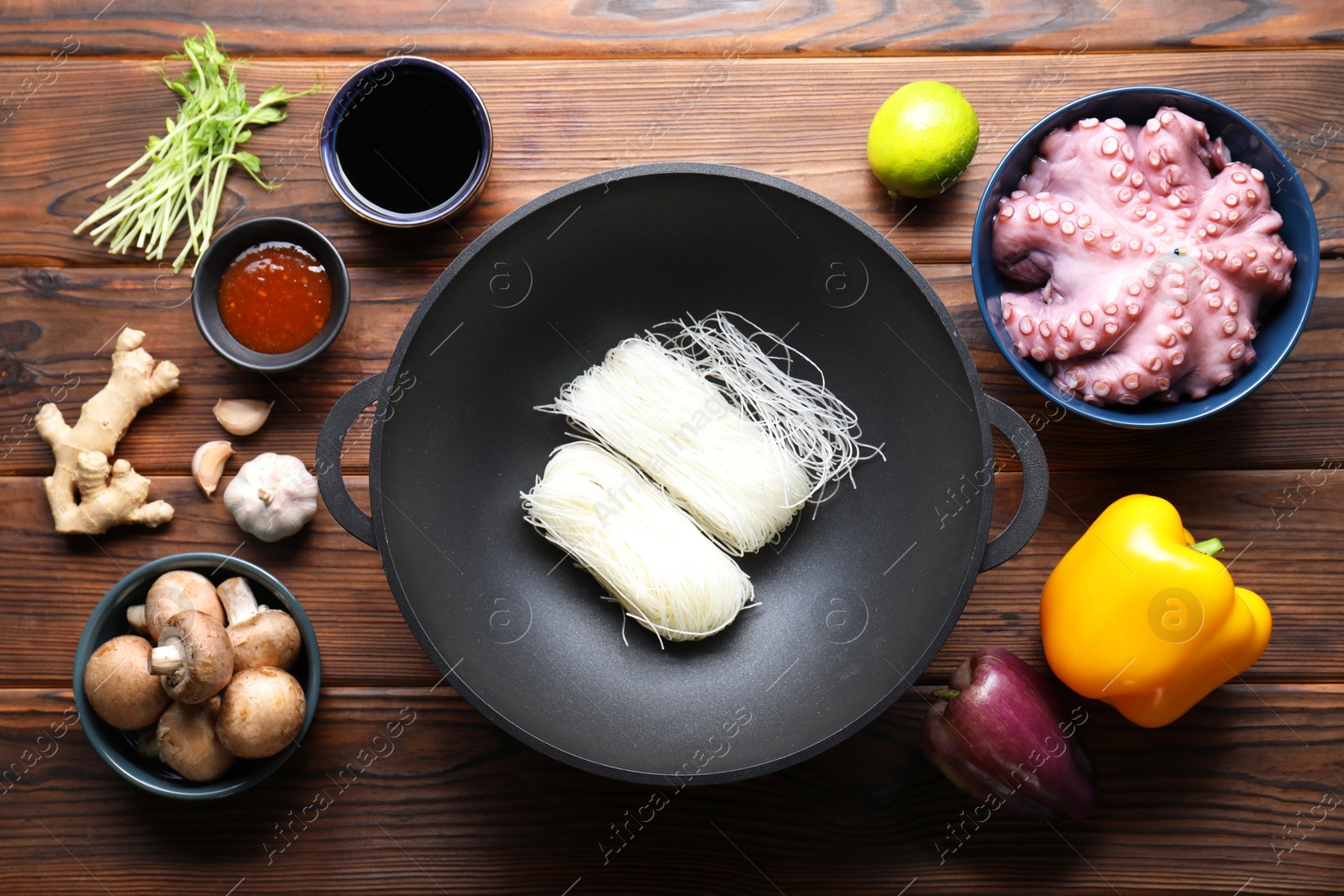 Photo of Different ingredients for wok on wooden table, flat lay