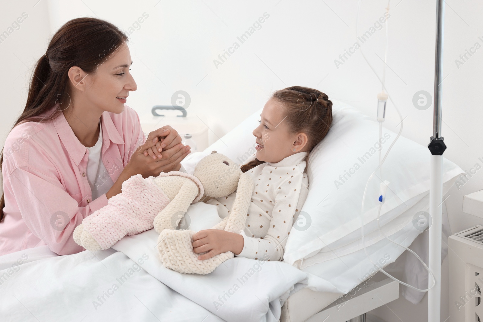 Photo of Mother and her little daughter on bed in hospital