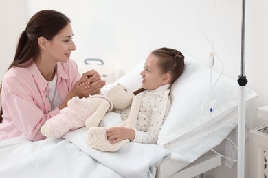 Photo of Mother and her little daughter on bed in hospital