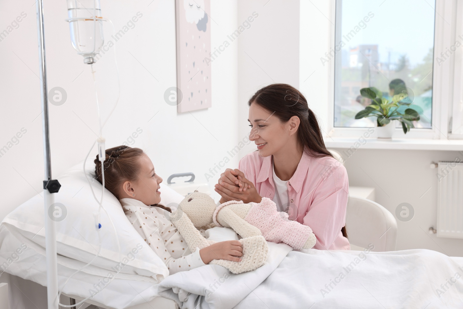 Photo of Mother and her little daughter on bed in hospital