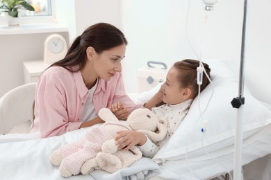 Mother and her little daughter on bed in hospital