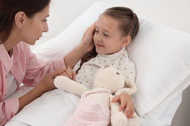 Photo of Mother and her little daughter on bed in hospital