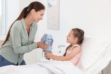 Mother and her little daughter on bed in hospital