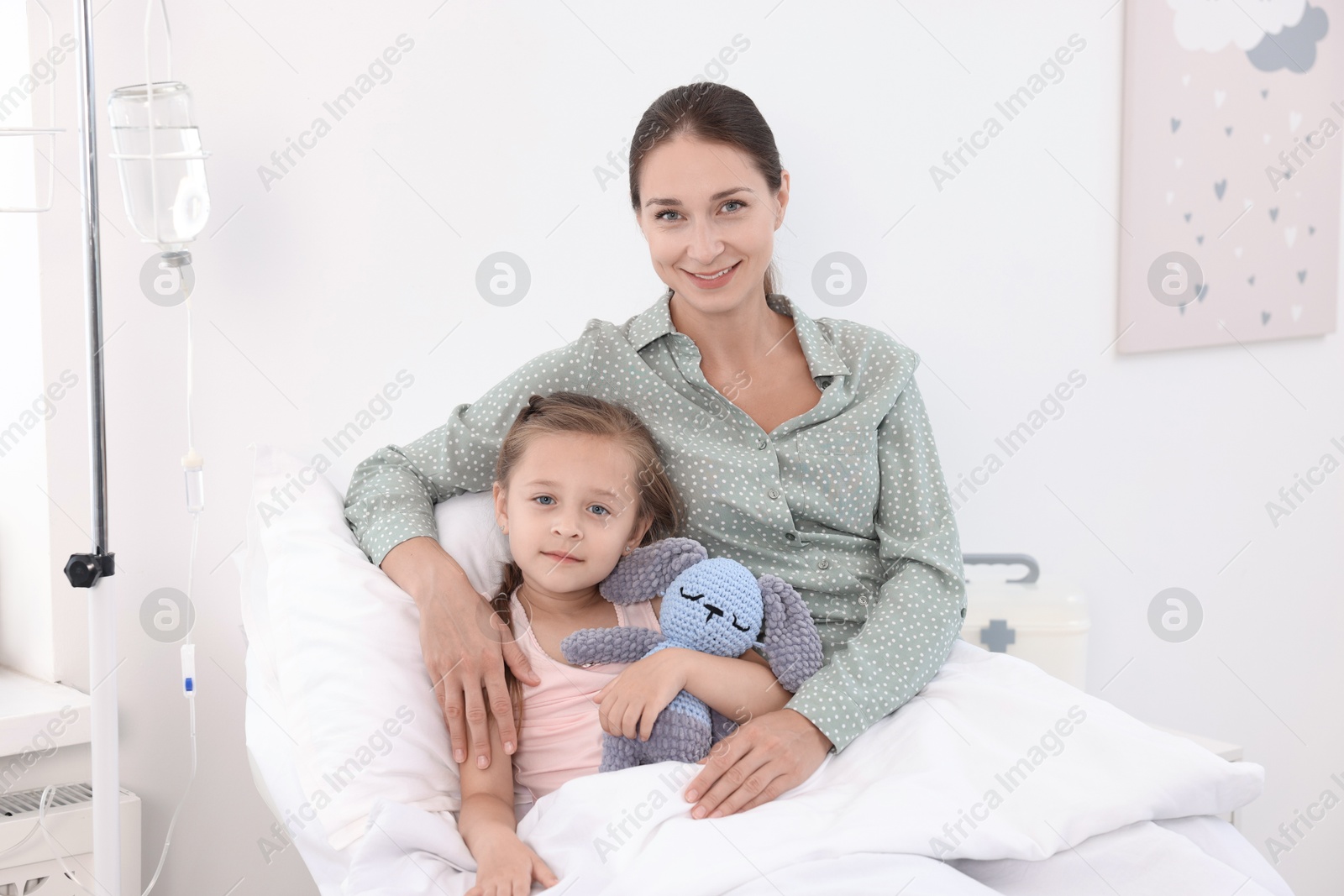 Photo of Mother and her little daughter on bed in hospital