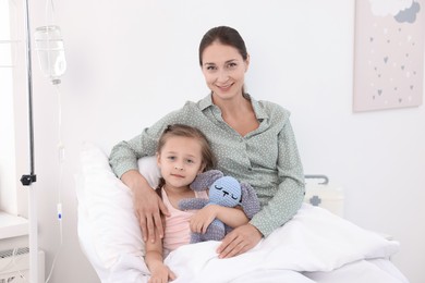 Mother and her little daughter on bed in hospital