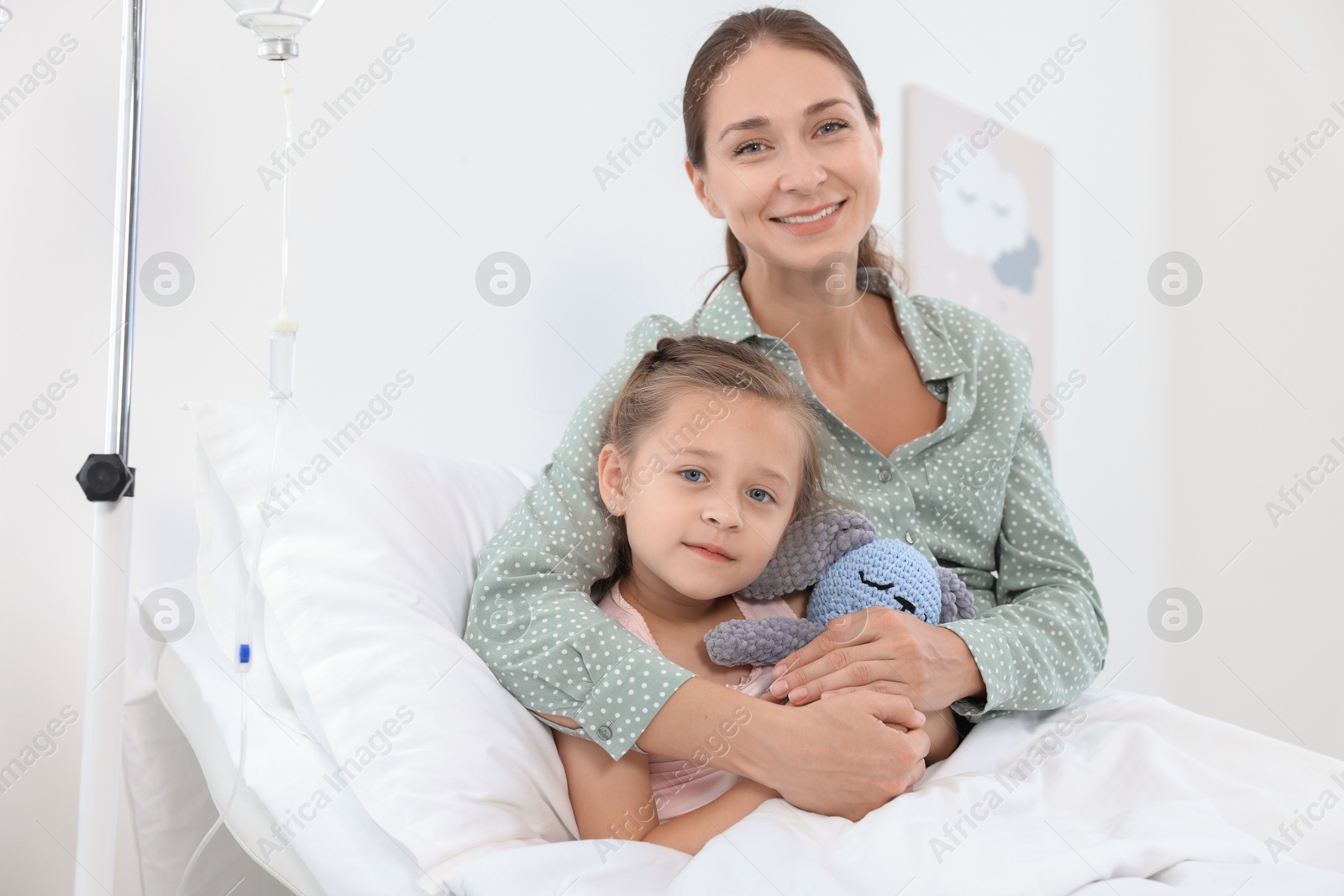 Photo of Mother and her little daughter on bed in hospital